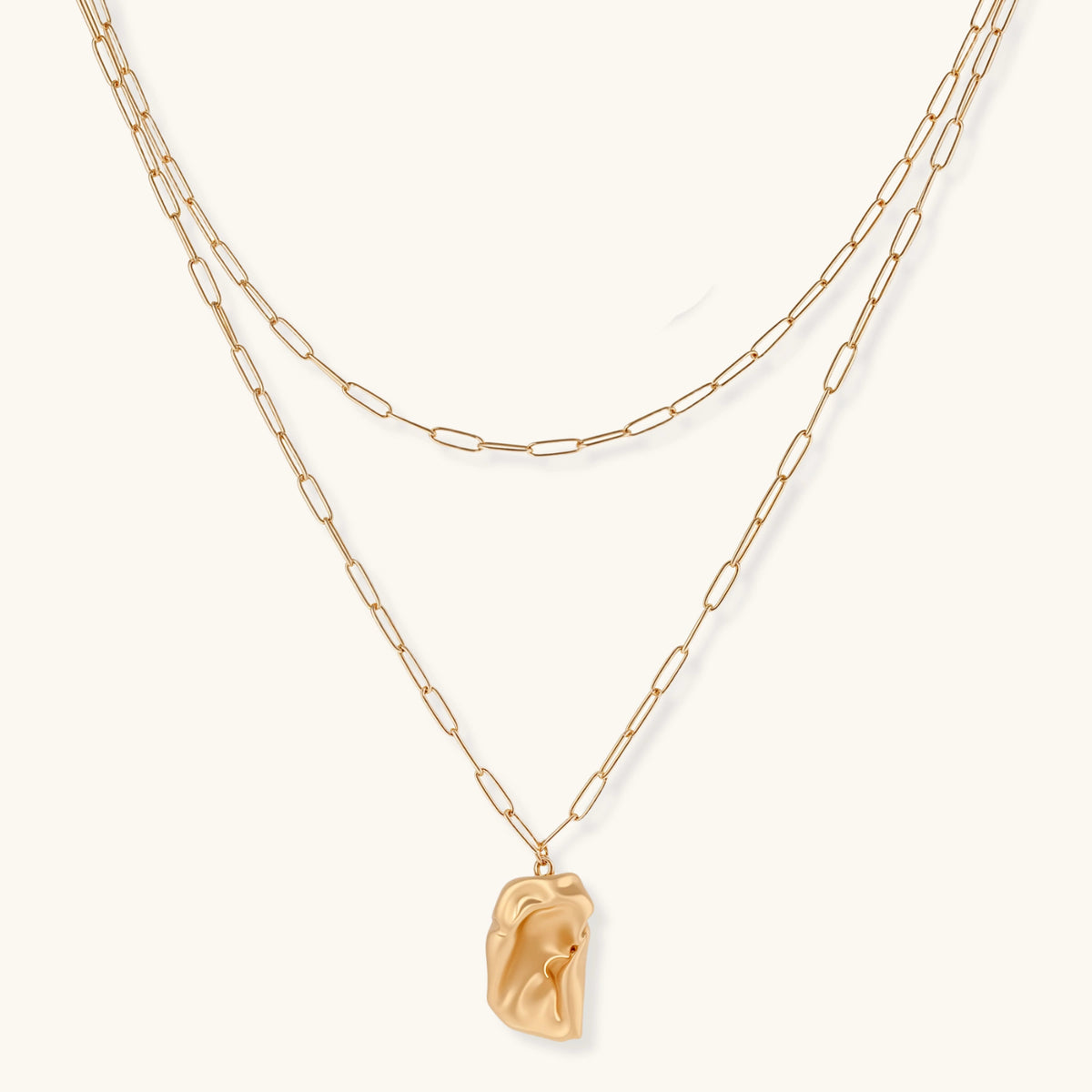 Layered paperclip chain necklace with organic flowing pendant made from eco-zinc alloy in warm gold finish